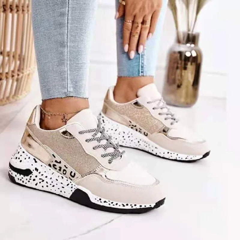 Femme portant des baskets blanches  or à semelles épaisses avec une maille respirante, style streetwear Zalmyraboutique.