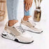Femme portant des baskets blanches  or à semelles épaisses avec une maille respirante, style streetwear Zalmyraboutique.