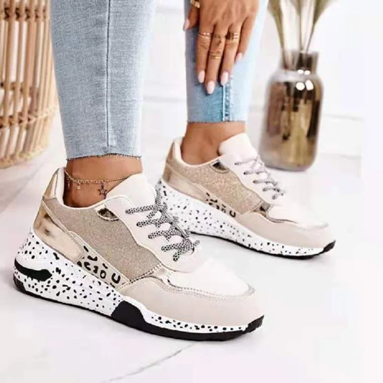 Femme portant des baskets blanches  or à semelles épaisses avec une maille respirante, style streetwear Zalmyraboutique.